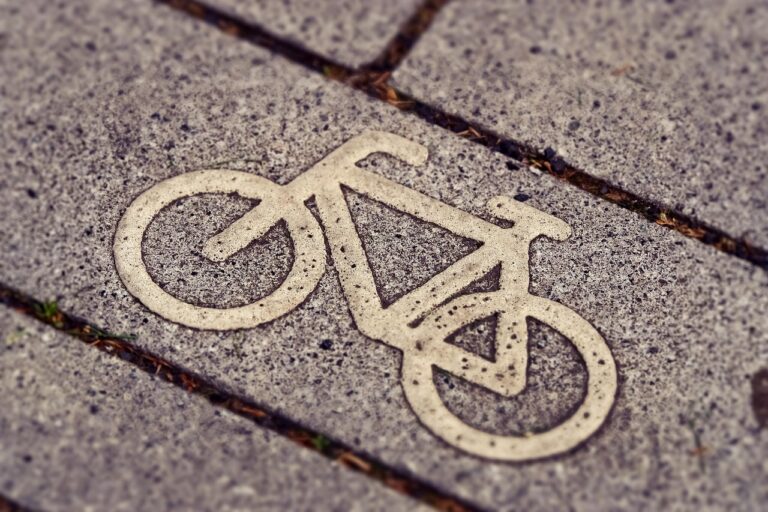 Kinderwagen wird sicher auf dem Radweg neben Fahrradfahrern geschoben
