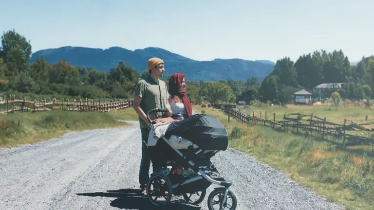 Paar mit Kinderwagen auf einem Feldweg